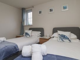 A bedroom with two single beds and artwork on the wall at Larpool Retreat in Whitby