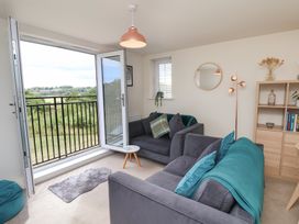 A living room with a couch and balcony door at Larpool Retreat in Whitby