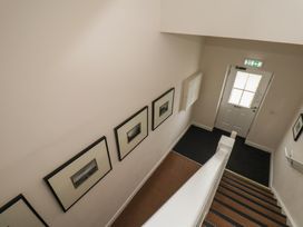 A staircase with pictures on the wall and a door at Larpool Retreat in Whitby