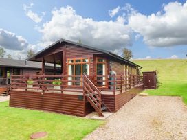 A cabin with a deck and lawn at Badgers Retreat - Two Dales Richmond