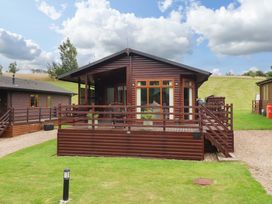 A cabin with a deck and grassy area at Badgers Retreat - Two Dales Richmond