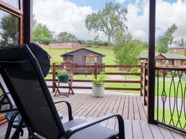 A deck view with a chair and planter at Badgers Retreat - Two Dales, Richmond