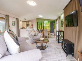 A living room with a sofa and dining area at Badgers Retreat - Two Dales, Richmond