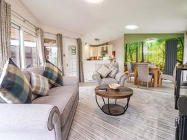 A living room with a sofa and dining area at Badgers Retreat - Two Dales, Richmond