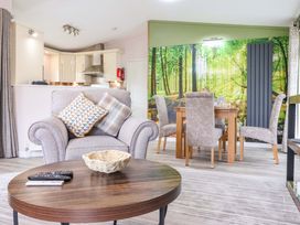 A living room with a sofa and dining area at Badgers Retreat - Two Dales, Richmond