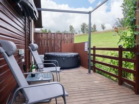 An outdoor area with a hot tub and chairs at Badgers Retreat - Two Dales Richmond