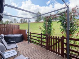 An outdoor area with a hot tub, chairs and a pergola at Badgers Retreat - Two Dales Richmond