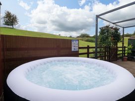 An outdoor area with a hot tub and wooden deck at Badgers Retreat - Two Dales, Richmond