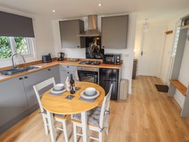 A kitchen with a table and chairs at Pear Tree Lodge in Alford