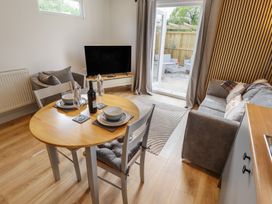 A living room with a table, chairs, and a sofa at Pear Tree Lodge in Alford