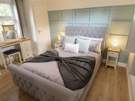 A bedroom with a bed and dressing table at Pear Tree Lodge in Alford