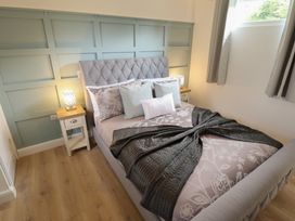 A bedroom with a bed and nightstand at Pear Tree Lodge in Alford
