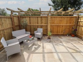 An outdoor seating area with furniture and plants at Pear Tree Lodge in Alford