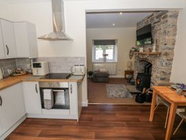 A kitchen with appliances and a living room with a sofa at Vern Dale in Builth Wells