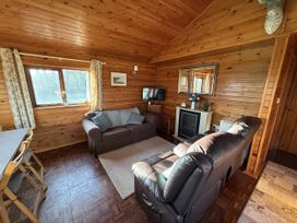 A living room with a sofa and television at Oak Lodge in Mynydd Cerrig near Porthyrhyd