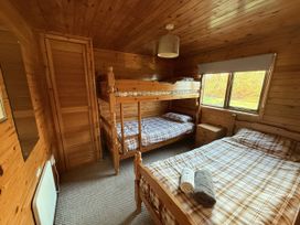 A bedroom with a bunk bed and a double bed at Oak Lodge Mynydd Cerrig near Porthyrhyd
