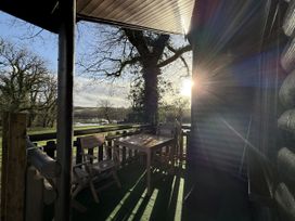 An outdoor patio with a table and chairs at Oak Lodge in Mynydd Cerrig near Porthyrhyd
