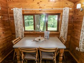 A dining room with a table and chairs at Oak Lodge Mynydd Cerrig near Porthyrhyd