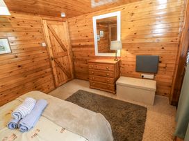 A bedroom with a bed and dressing table at Oak Lodge in Mynydd Cerrig near Porthyrhyd