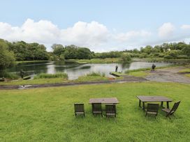 An outdoor area with a lake and fishing activity at Oak Lodge near Mynydd Cerrig