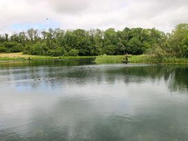 A person fishing from a platform on a lake at Oak Lodge in Mynydd Cerrig near Porthyrhyd