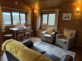 A living room with a table and chairs at Ash Lodge in Mynydd Cerrig near Porthyrhyd
