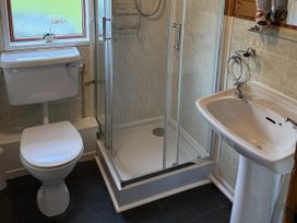 A bathroom with a toilet, shower, and sink at Ash Lodge near Mynydd Cerrig