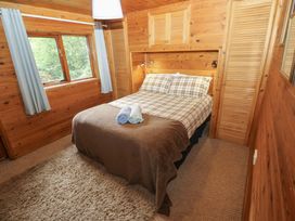 A bedroom with a bed and window at Ash Lodge in Mynydd Cerrig near Porthyrhyd