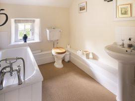 A bathroom with a bathtub, toilet, and sink at West Cottage in Llandovery