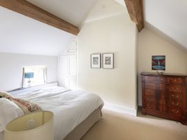 A bedroom with a bed and a dresser at West Cottage in Llandovery