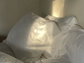 A bed with white pillows and sheets at West Cottage Myddfai near Llandovery