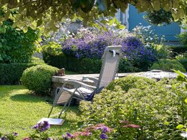 A garden with a lounge chair and flowers at West Cottage Myddfai near Llandovery