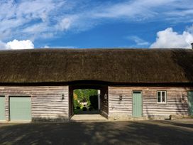 A building with a thatched roof and green doors at West Cottage Myddfai near Llandovery
