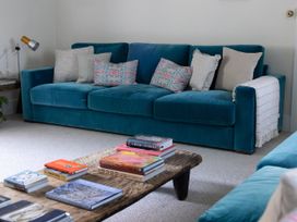 A living room with a sofa, coffee table and books at West Cottage in Myddfai near Llandovery