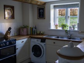 A kitchen with a washing machine and oven at West Cottage near Llandovery