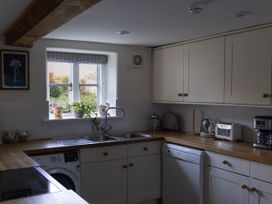 A kitchen with a sink, window, and appliances at West Cottage in Myddfai near Llandovery