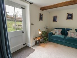 A living room with a sofa and a door leading to the outside at West Cottage in Myddfai near Llandovery