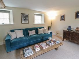 A living room with a blue sofa books and a globe at West Cottage Myddfai near Llandovery