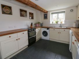 A kitchen with an oven and washing machine at West Cottage near Llandovery