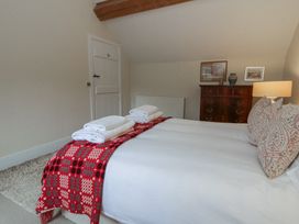 A bedroom with a bed, dresser, and towels at West Cottage in Myddfai near Llandovery
