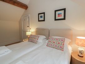 A bedroom with two beds and a lamp at West Cottage in Myddfai near Llandovery