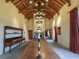 A dining room with a long table and chandelier at West Cottage Myddfai near Llandovery
