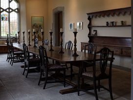 A dining room with a long table and chairs at West Cottage in Myddfai near Llandovery