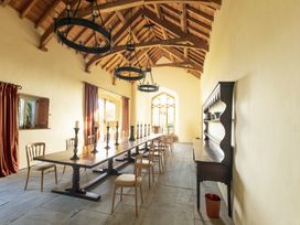 A dining room with a long table and chairs at Gatekeepers Cottage in Llandovery