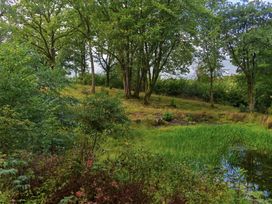 A landscape with trees and a pond at Gatekeepers Cottage in Llandovery