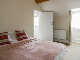 A bedroom with a bed and curtains at Gatekeepers Cottage in Myddfai near Llandovery