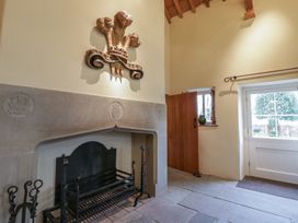 A hallway with a fireplace and wooden door at Gatekeepers Cottage Myddfai near Llandovery