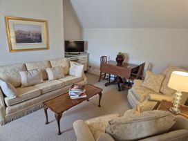 A sitting room with sofas and a dining table at Gatekeepers Cottage in Myddfai near Llandovery