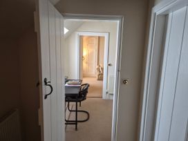 A hallway leading to a study area with a desk and chair at Gatekeepers Cottage Myddfai near Llandovery