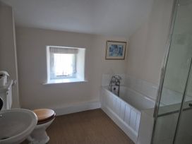 A bathroom with a bathtub and toilet at Gatekeepers Cottage Myddfai near Llandovery